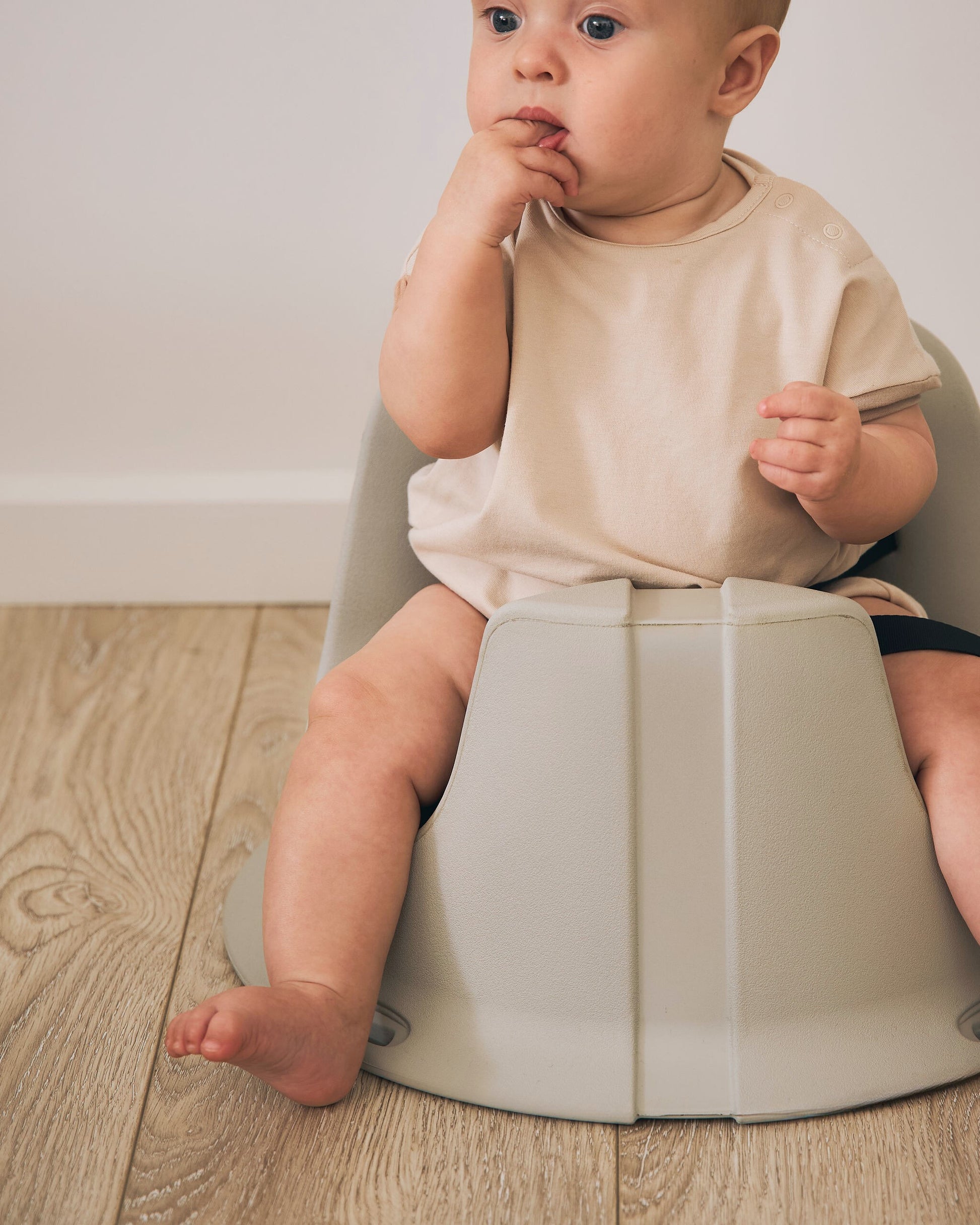 Baby using the hip & co floor seat, showing supportive design for early sitting.