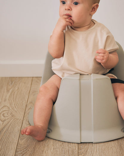 Baby using the hip & co floor seat, showing supportive design for early sitting.