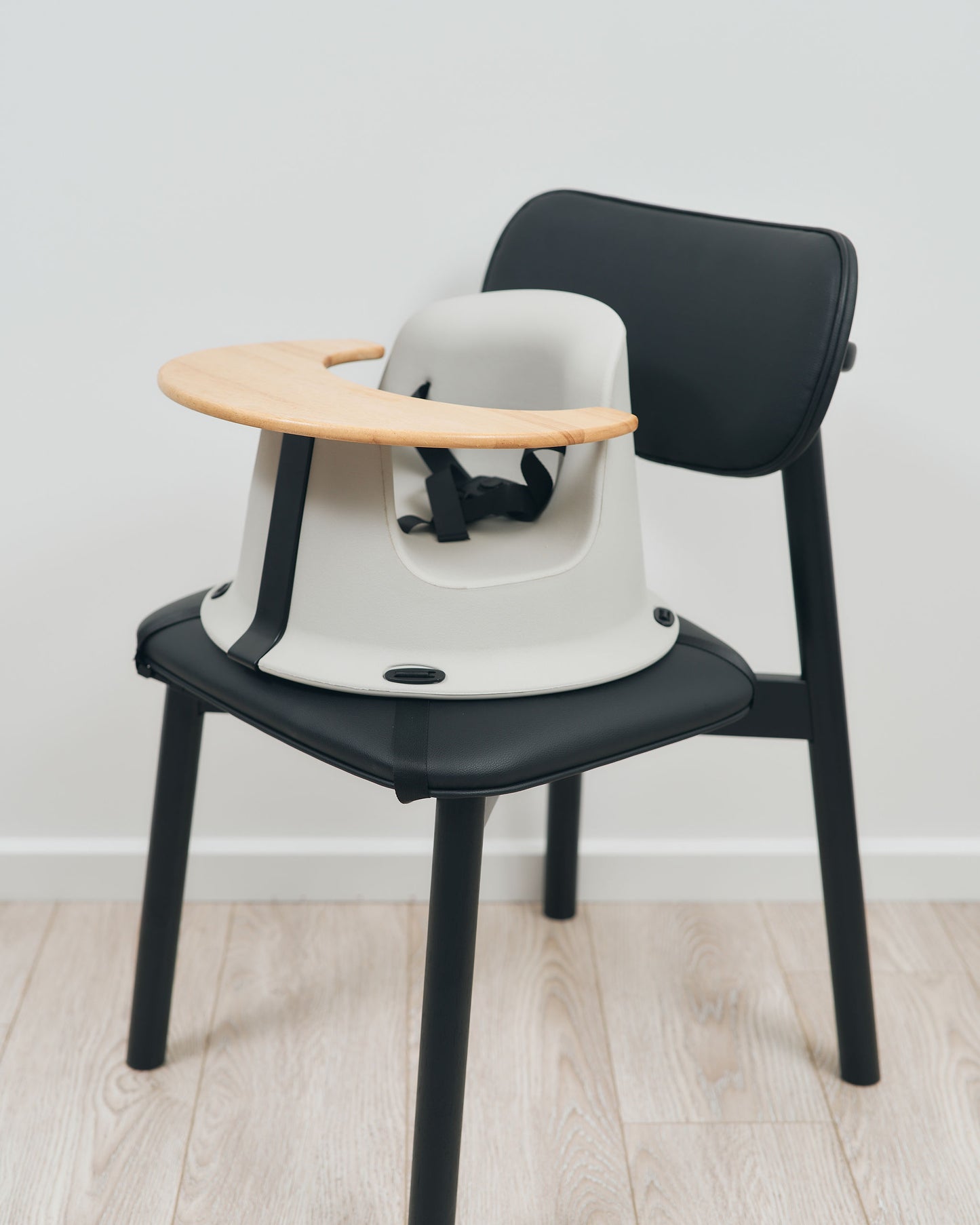 Hip & Co baby floor seat used as a booster seat secured to an adult chair.