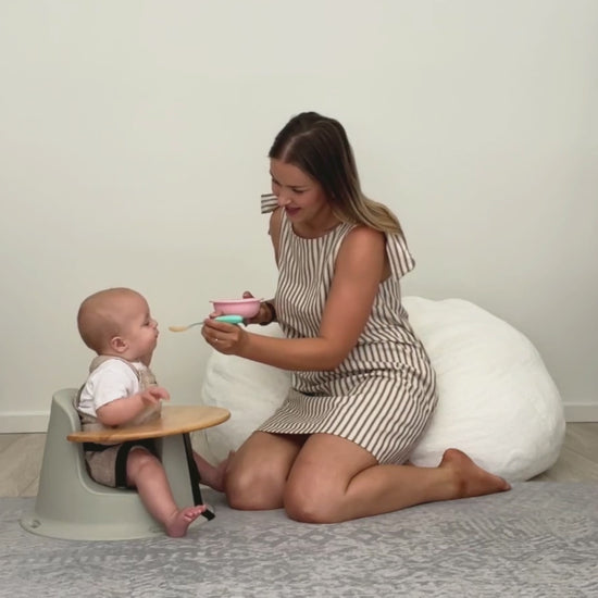 mum feeding baby in floor seat